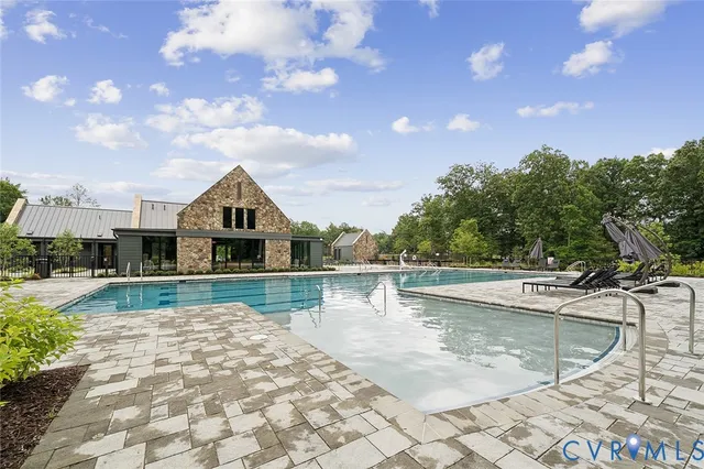 an aerial view of a residential houses with outdoor space and trees