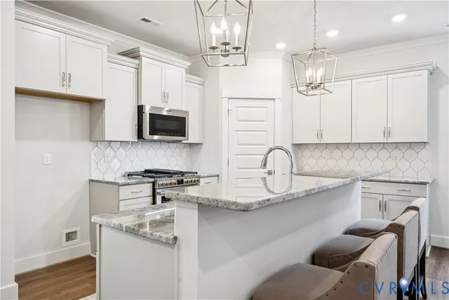 a kitchen with stainless steel appliances granite countertop a sink a stove and a refrigerator