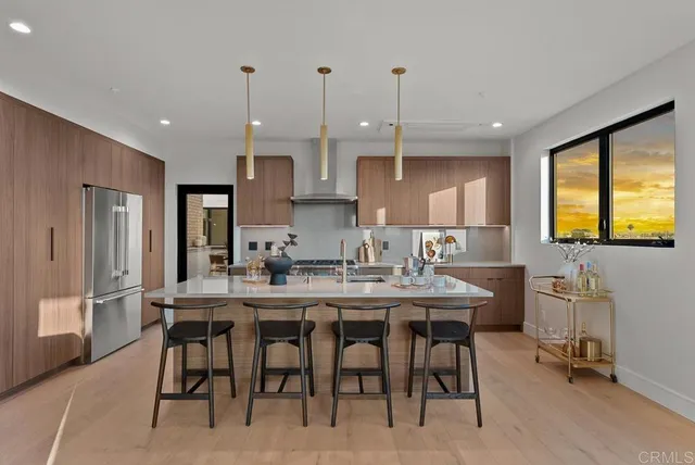 a kitchen with kitchen island granite countertop a table chairs sink and cabinets