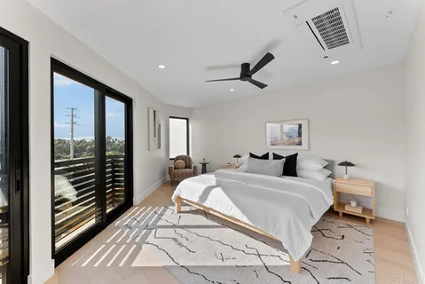 a bedroom with a bed and a large window