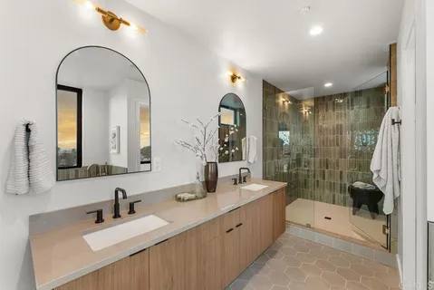 a spacious bathroom with a bathtub shower sink mirror and toilet