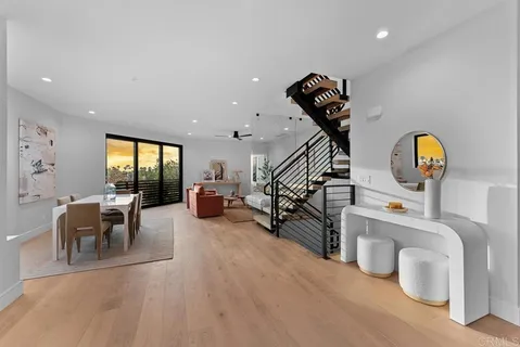 a living room with furniture a wooden floor and potted plant