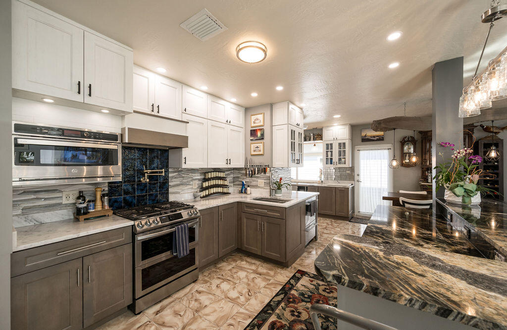 1407 Rose Street Key West, FL 33040 - Photo 27 of 74 a kitchen with stainless steel appliances granite countertop a stove top oven a sink a counter space and cabinets
