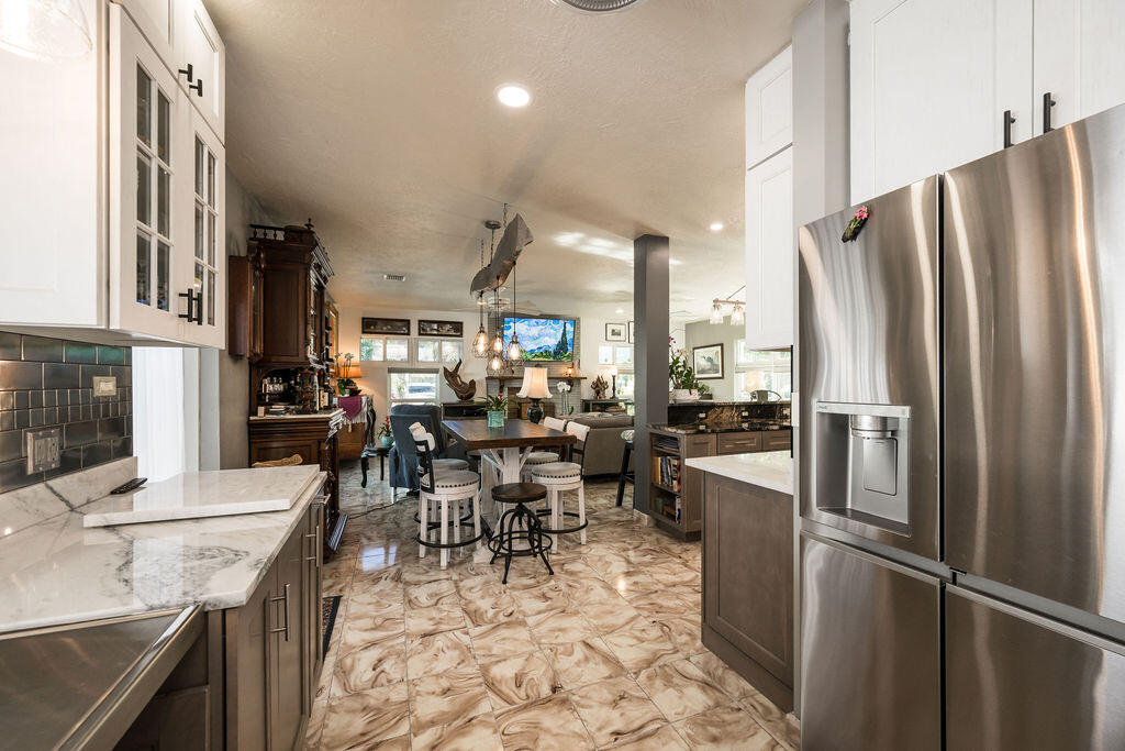 1407 Rose Street Key West, FL 33040 - Photo 32 of 74 a kitchen with stainless steel appliances kitchen island granite countertop dining table chair and a refrigerator
