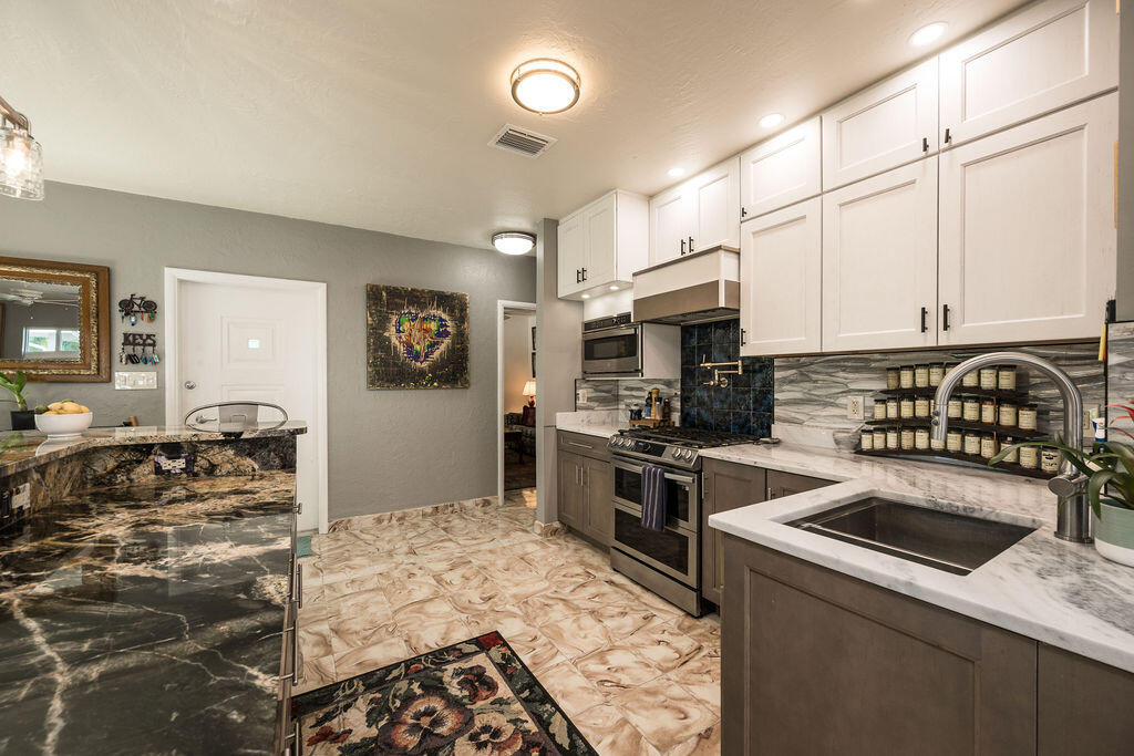 1407 Rose Street Key West, FL 33040 - Photo 34 of 74 a kitchen with stainless steel appliances granite countertop a stove sink and cabinets
