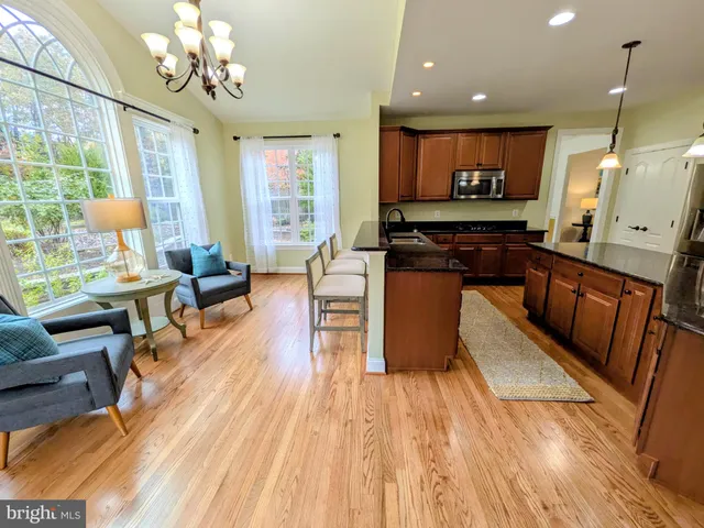 a kitchen with a dining table chairs and cabinets