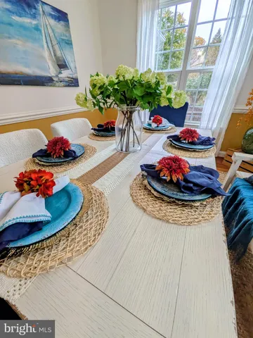 a dining room with furniture a large window and a chandelier