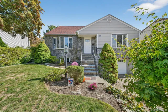 a front view of a house with a yard and potted plants