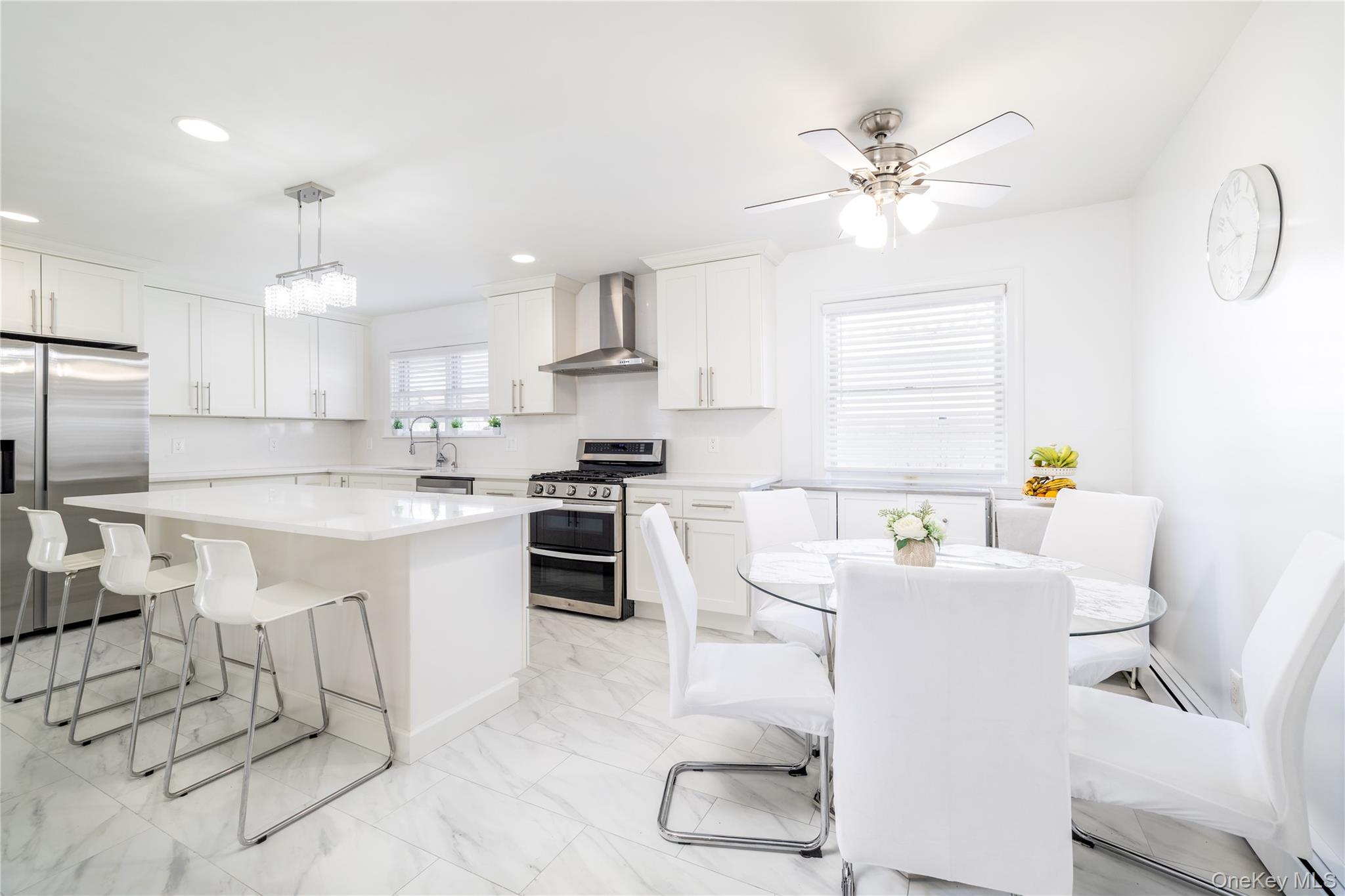 458 East Pine Street Long Beach, NY 11561 - Photo 6 of 26 a kitchen with stainless steel appliances a sink a stove a refrigerator cabinets and dining table