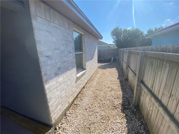 a view of an empty room and chandelier fan and window