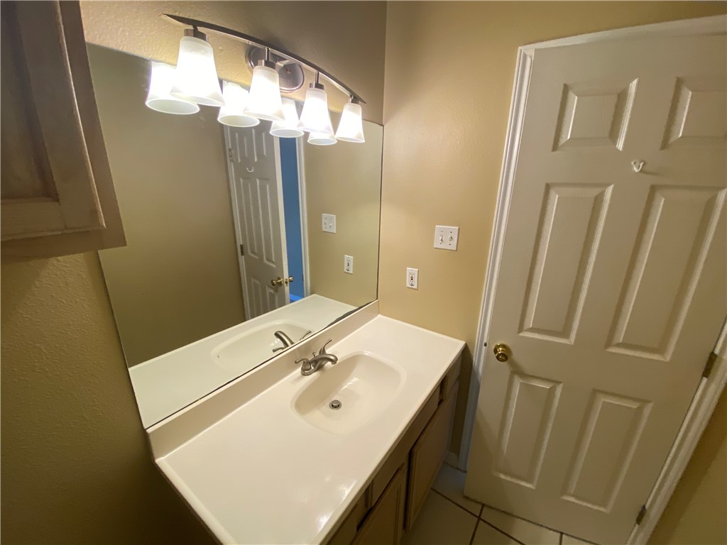 15410 Cruiser Street, Unit B Corpus Christi, TX 78418 - Photo 17 of 25 a bathroom with a sink a mirror and vanity