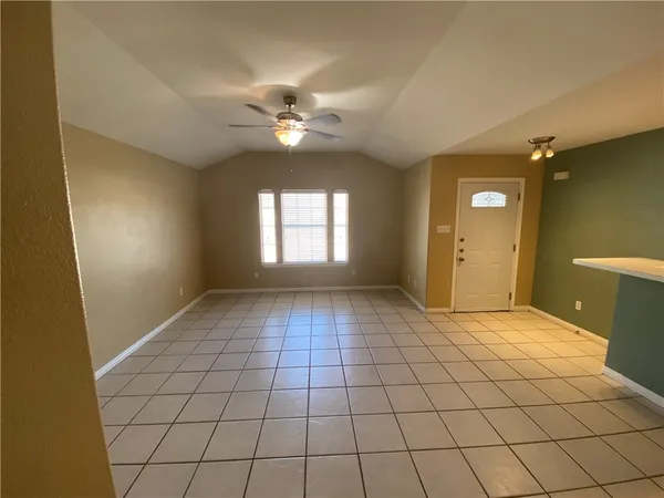 a view of a hallway to room with wooden floor