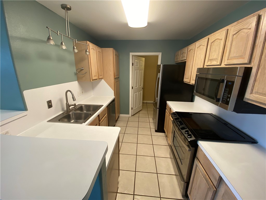 15410 Cruiser Street, Unit B Corpus Christi, TX 78418 - Photo 7 of 25 a kitchen with a sink appliances and cabinets