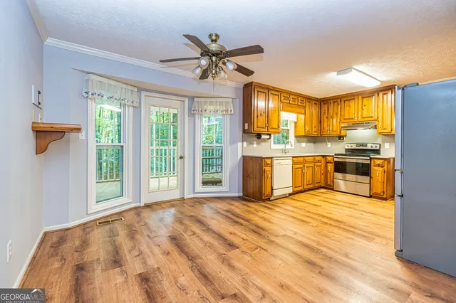 a view of an empty room with a window and wooden floor