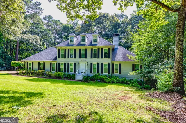 a front view of a house with yard and green space