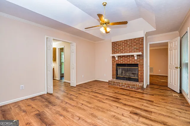 an empty room with wooden floor closet and windows