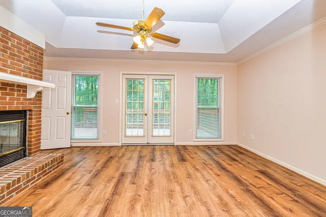 a view of an empty room with a window and a ceiling fan