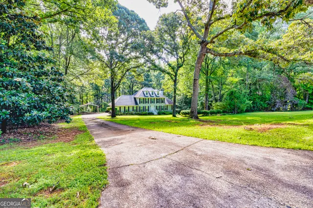 a view of an empty room with wooden floor and stairs