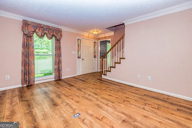 a view of empty room with a fireplace and wooden floor