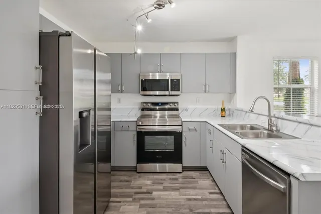 a kitchen with a sink cabinets and stainless steel appliances