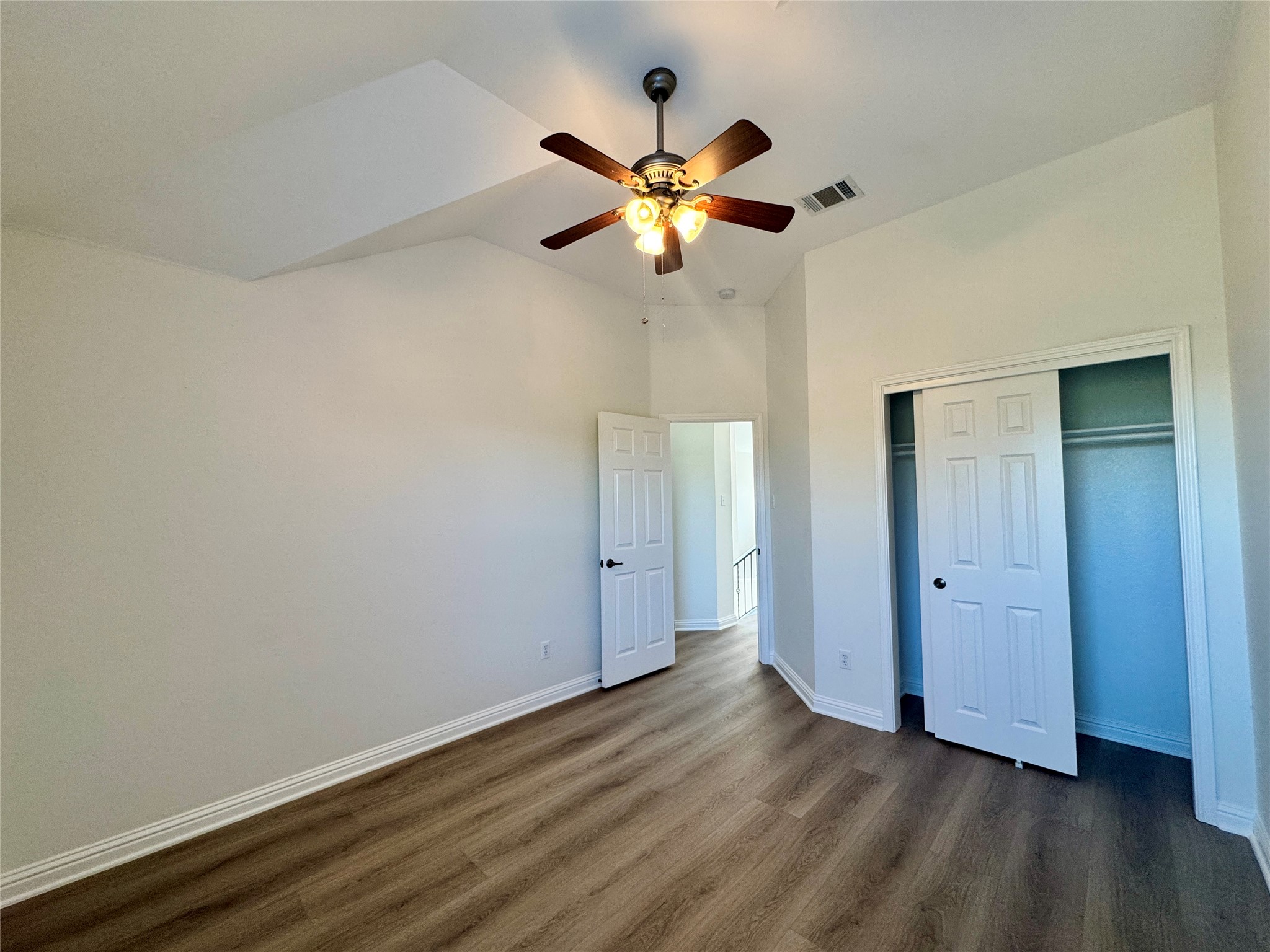 3640 Fossilwood Way Round Rock, TX 78681 - Photo 18 of 19 Unfurnished bedroom with dark wood finished floors, a ceiling fan, a closet, and lofted ceiling