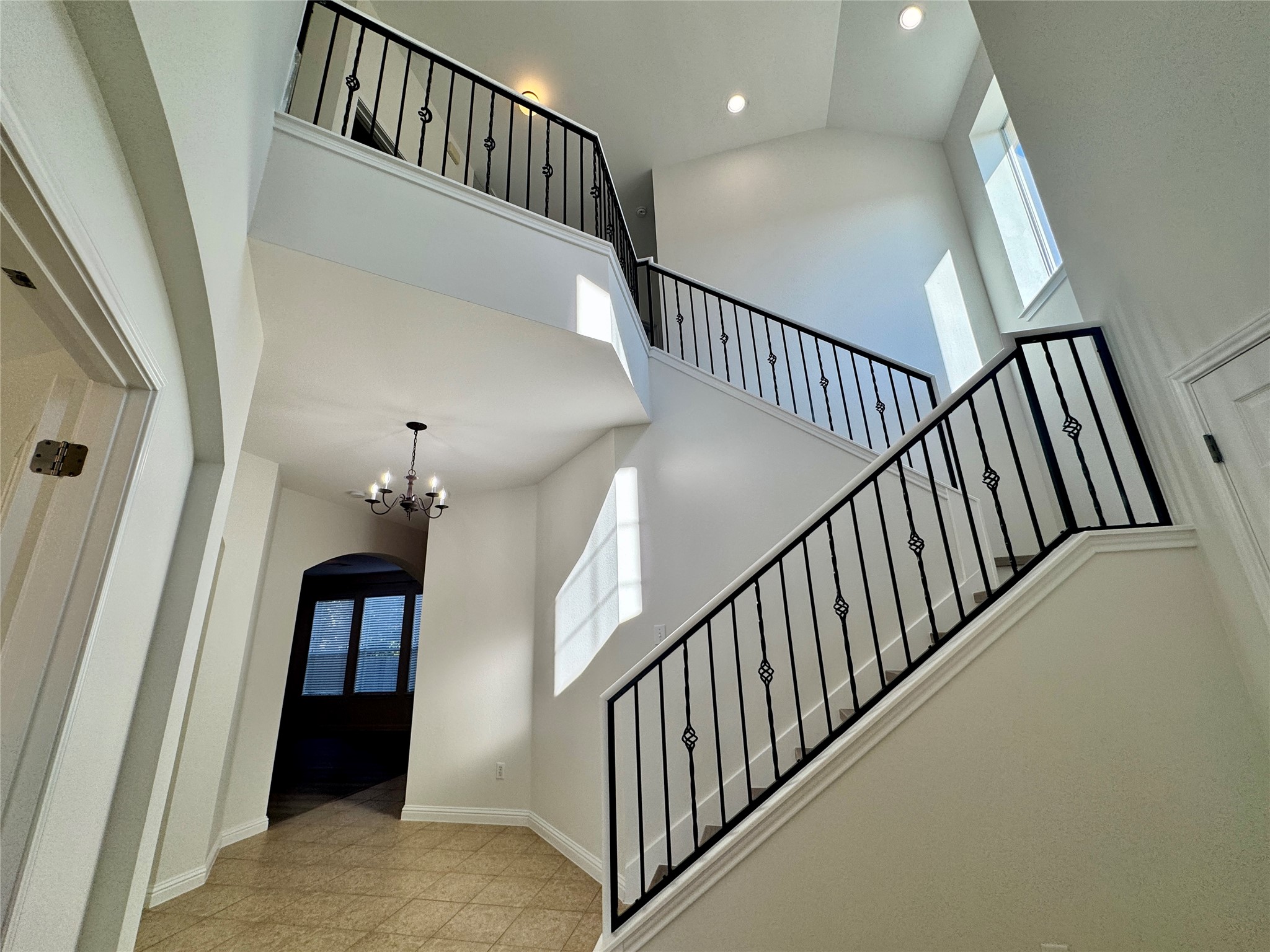 3640 Fossilwood Way Round Rock, TX 78681 - Photo 3 of 19 Stairway featuring arched walkways, a high ceiling, a chandelier, and recessed lighting