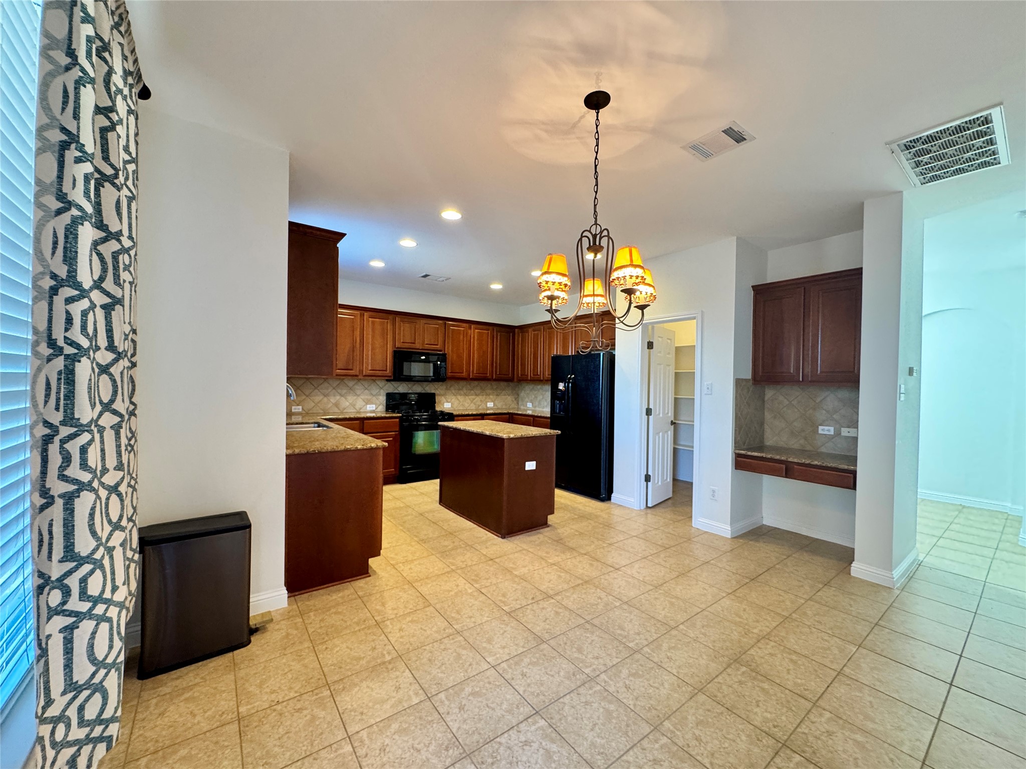 3640 Fossilwood Way Round Rock, TX 78681 - Photo 7 of 19 Kitchen featuring a center island, hanging light fixtures, black appliances, decorative backsplash, and a chandelier