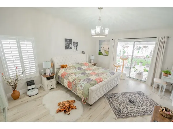 a bedroom with a bed mirror and window