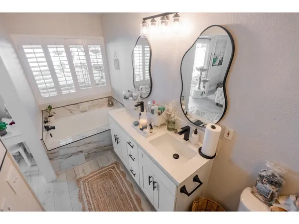 a bathroom with double vanity sink and a mirror