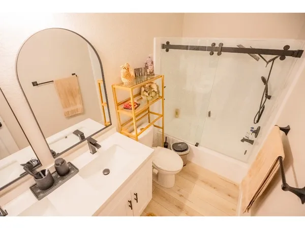 a bathroom with a sink mirror vanity and toilet