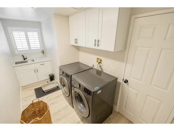 a utility room with cabinets washer and dryer