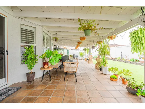 a view of a patio with table and chairs potted plants