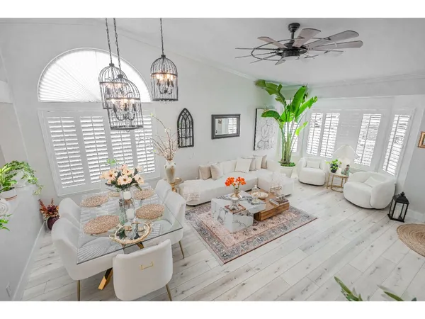 a living room with furniture a chandelier and a window