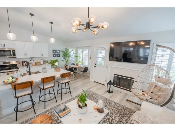 a living room with furniture a flat screen tv and kitchen view