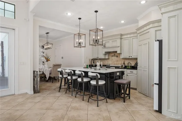 a kitchen with kitchen island a dining table chairs cabinets and stainless steel appliances