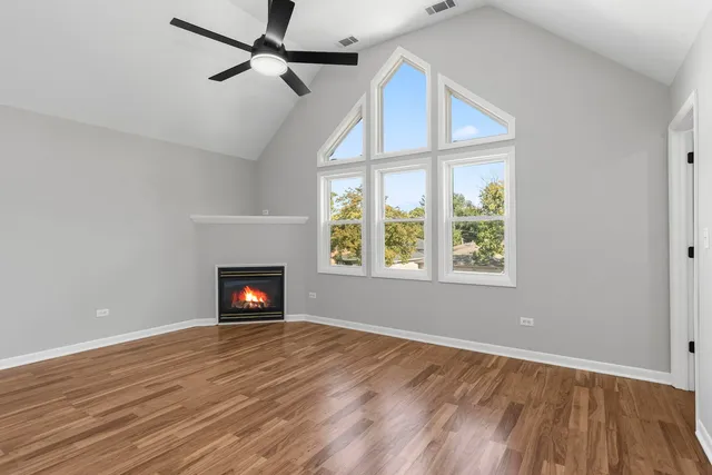 an empty room with windows a fireplace