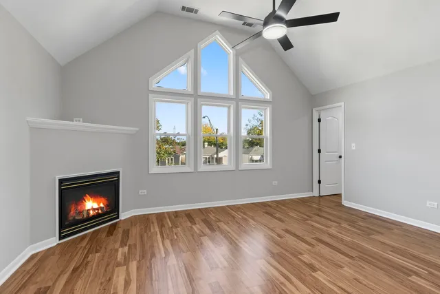 an empty room with windows and fireplace