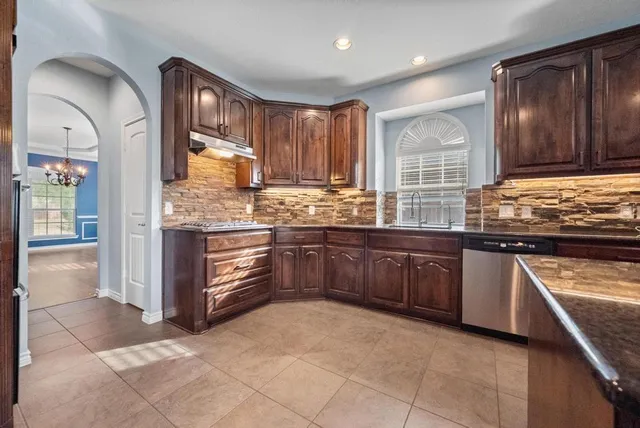 a kitchen with stainless steel appliances granite countertop a stove and cabinets