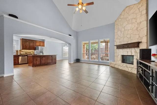 a view of an empty room with a fireplace and a window
