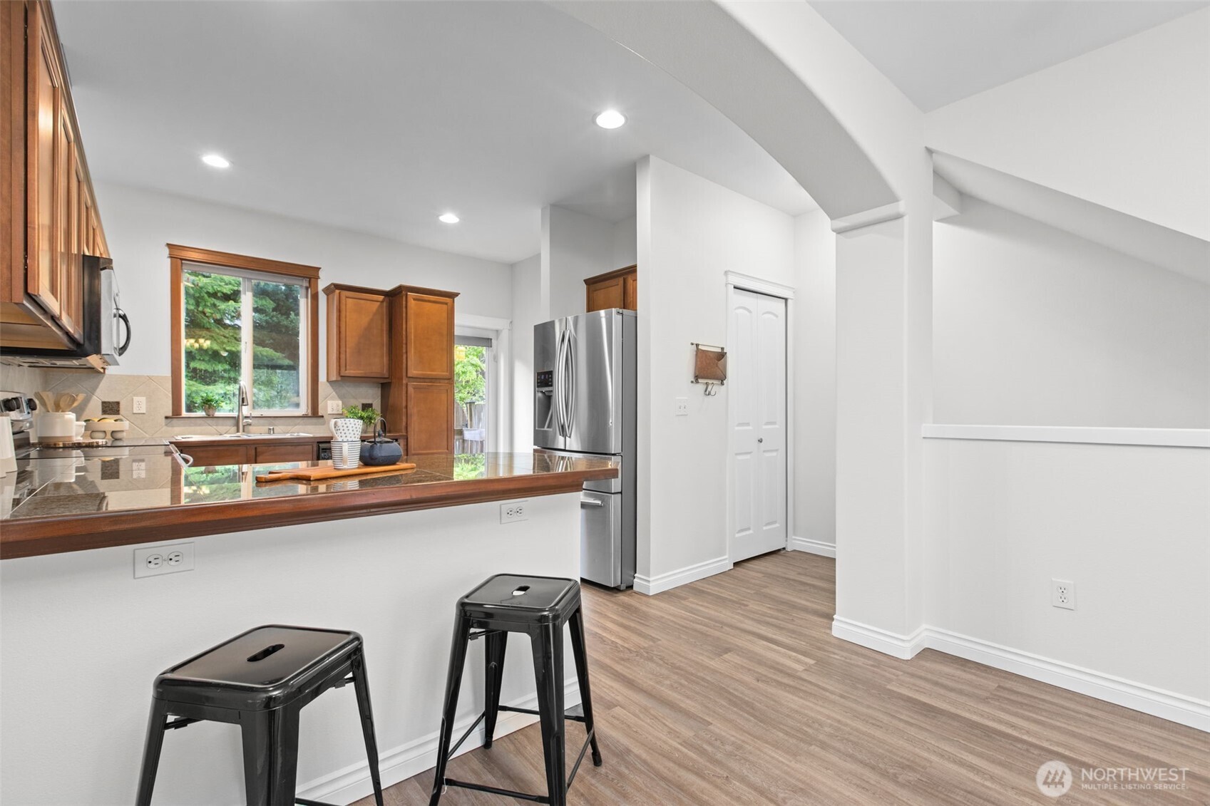 532 Pilchuck Path Everett, WA 98201 - Photo 8 of 37 a kitchen with stainless steel appliances granite countertop a refrigerator a sink a stove and white cabinets with wooden floor