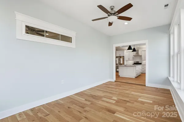 a big room with wooden floor and a ceiling fan