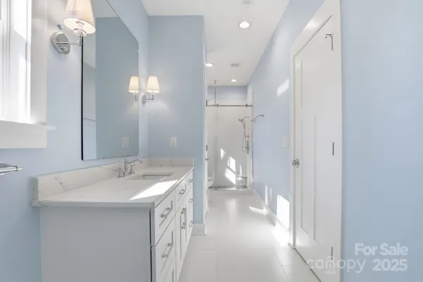 a spacious bathroom with a sink a mirror and a shower