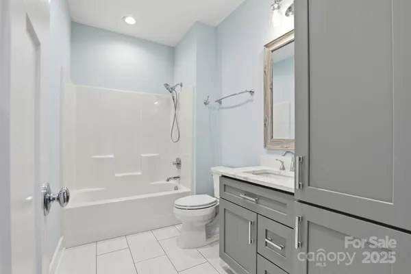 a bathroom with a granite countertop sink a toilet and shower