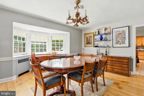 a dining room with furniture a chandelier and wooden floor