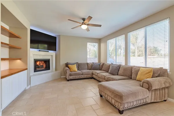 a living room with furniture a flat screen tv and a fireplace