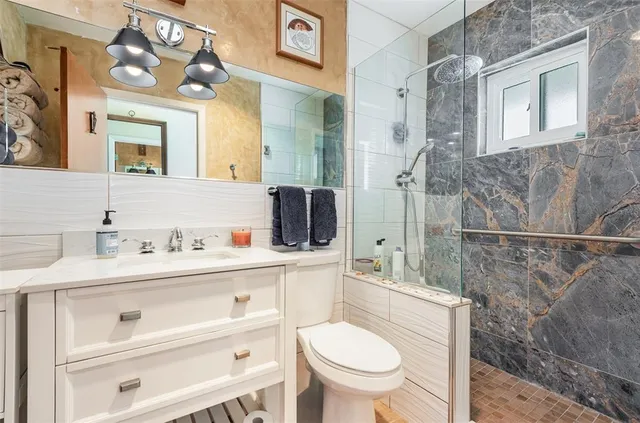 a bathroom with a sink a toilet and shower