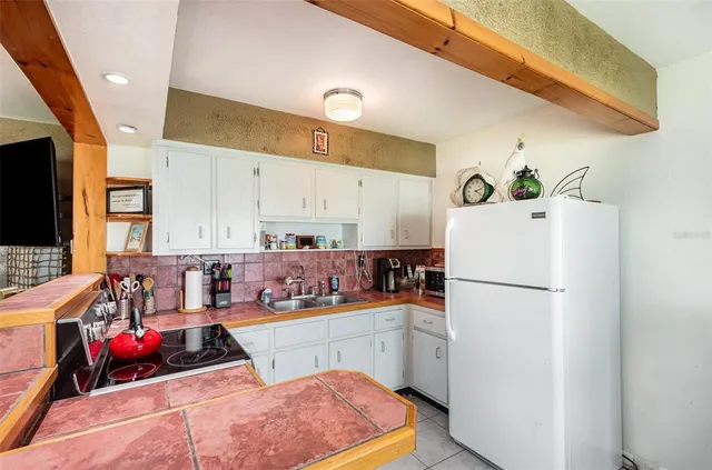 a kitchen with stainless steel appliances a refrigerator sink and white cabinets