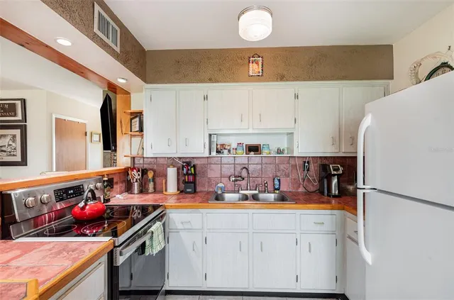 a kitchen with stainless steel appliances a stove a sink and a refrigerator