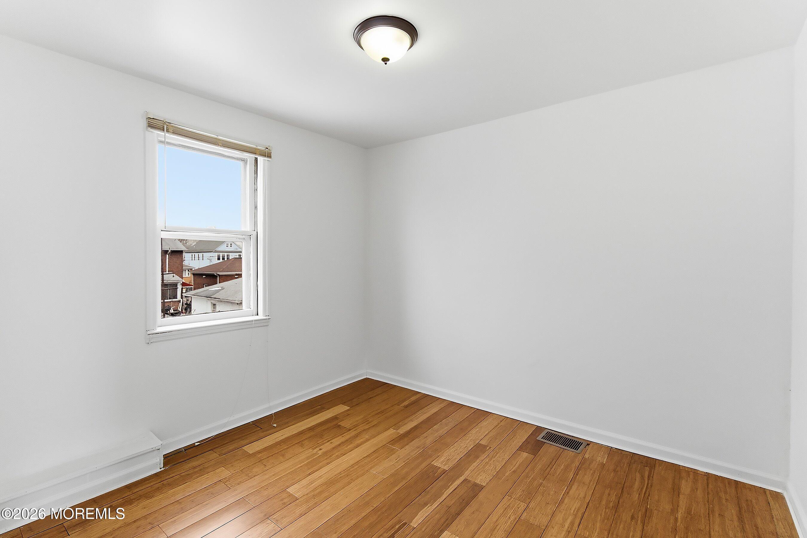 46 West 12th Street Linden, NJ 07036 - Photo 11 of 18 an empty room with wooden floor and windows