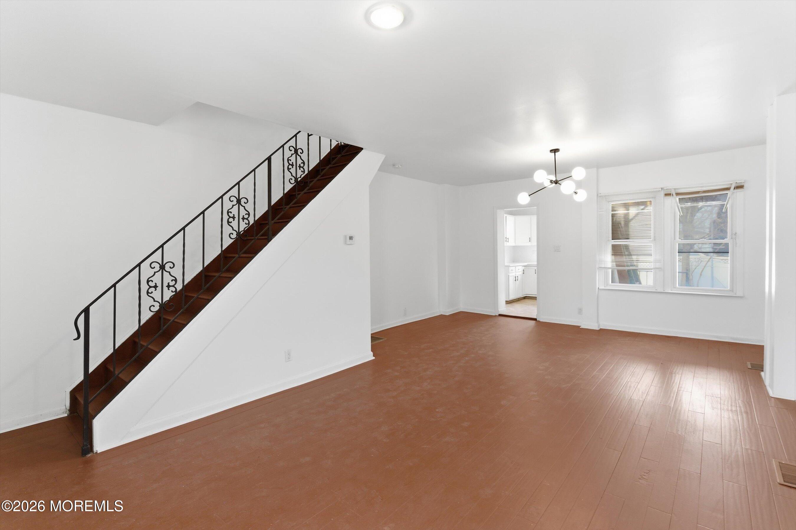 46 West 12th Street Linden, NJ 07036 - Photo 5 of 18 a view of an empty room with wooden floor and stairs